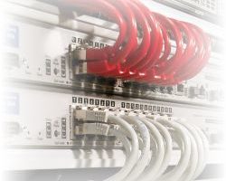 Stojak serwerów z czerwonymi i białymi przewodami wyposażonymi w elektrykę.
